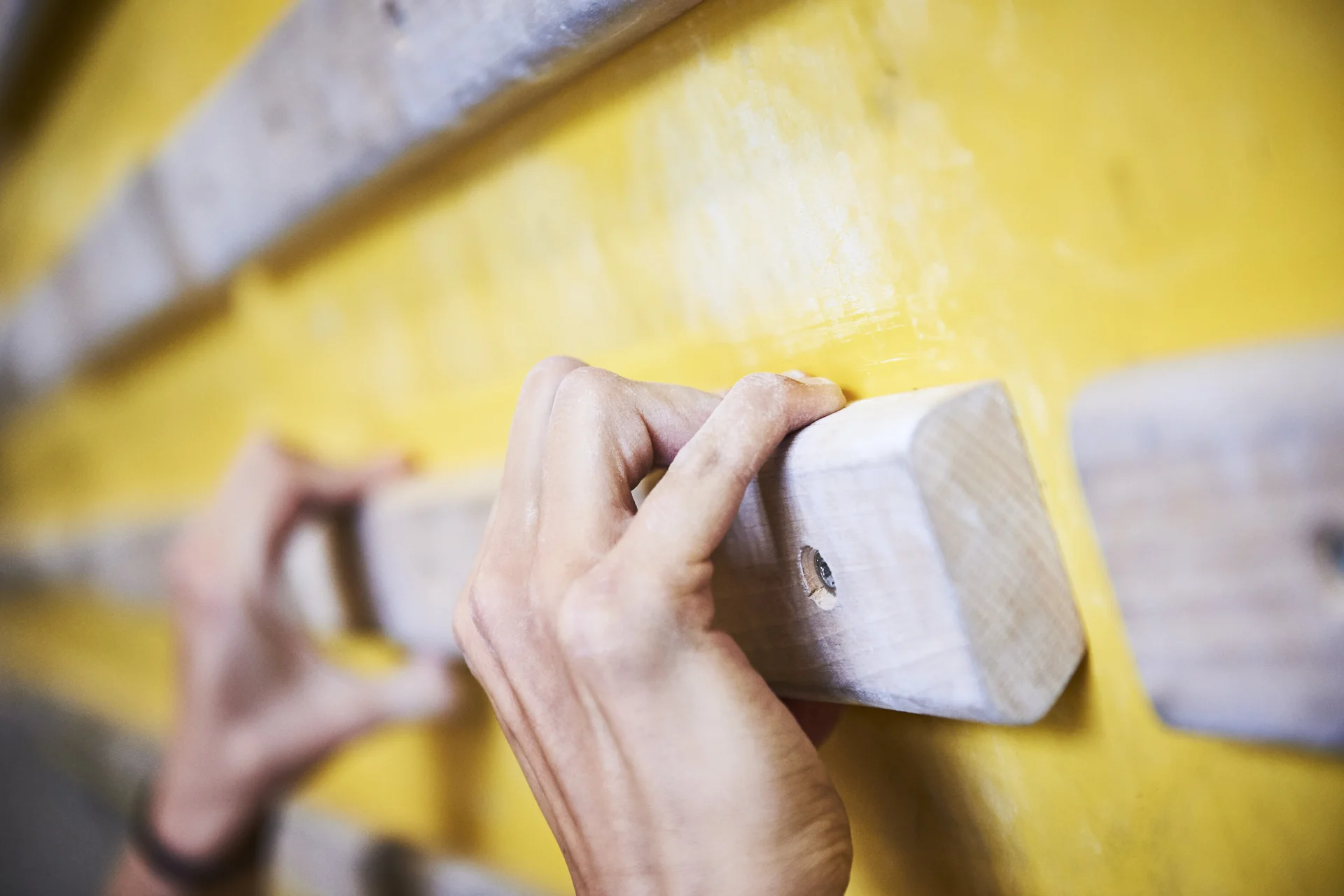 DAV Kletterhalle | © DAV/Frank Kretschmann Hände greifen nach Holzelementen an einer Kletterwand | © DAV/Frank Kretschmann